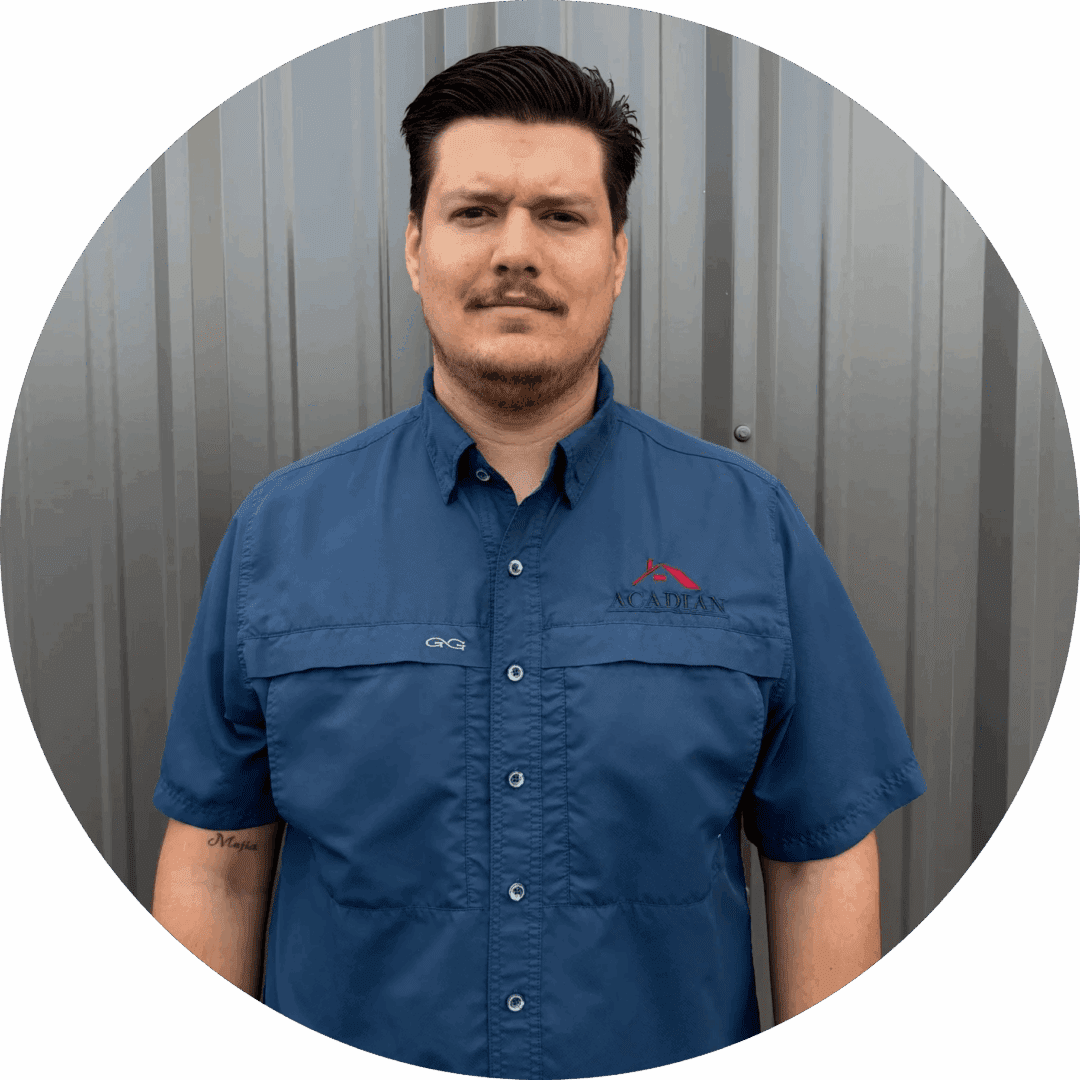 Man in blue shirt, standing, neutral background.