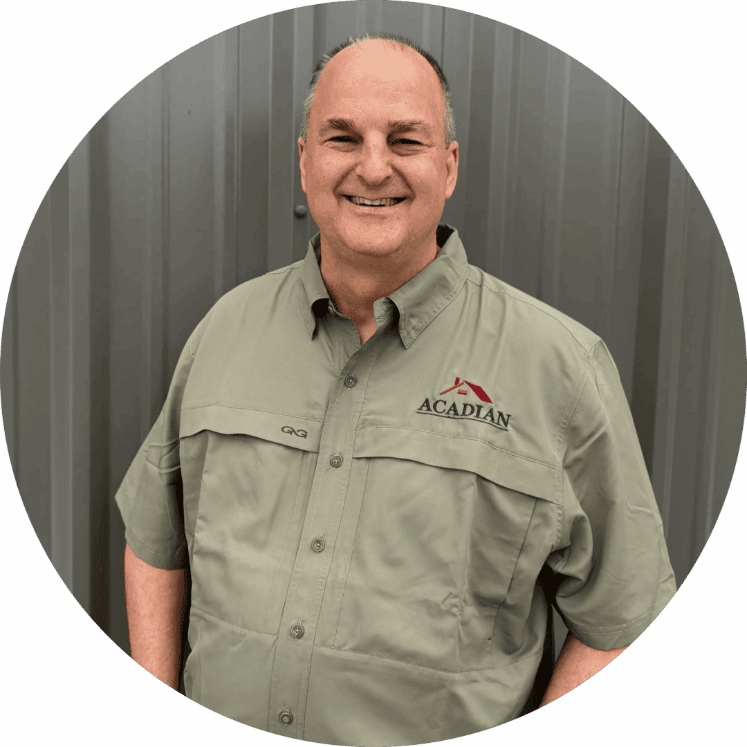 Man smiling in Acadian logo shirt.